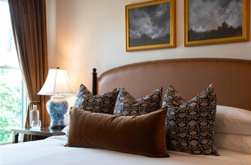 a bedroom with a bed with pillows and a lamp at Hotel Burg in Leesburg