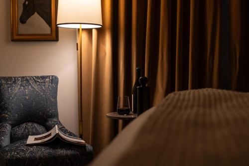 a bedroom with a chair and a lamp and a bed at Hotel Burg in Leesburg