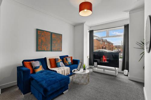 a living room with a blue couch and a tv at Styllish 3 bed House in Central Hull in Hull
