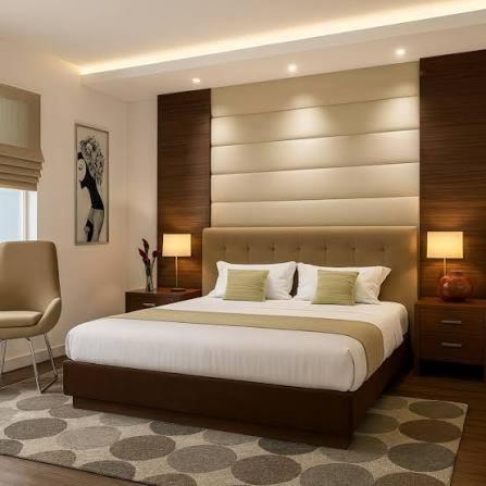 a bedroom with a large bed and a chair at دوبلكس شرق in Madīnat ash Shurūq