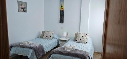 a room with two beds with towels on them at Ático carrizal in Carrizal