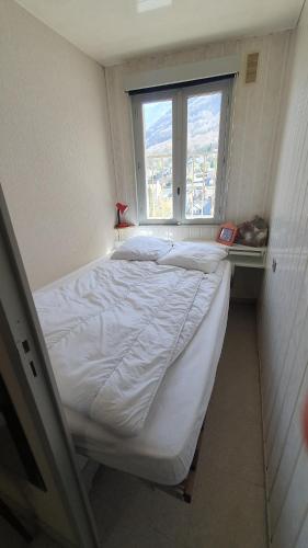 a bed in a small room with a window at appartement 4 places centre-ville in Cauterets