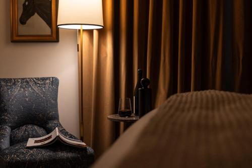 a bedroom with a chair and a table with a lamp at Hotel Burg in Leesburg