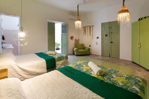 a bedroom with two beds and a green cabinet at Casa La Gloria, Centro de Mérida, Hasta 16 Huéspedes in Mérida
