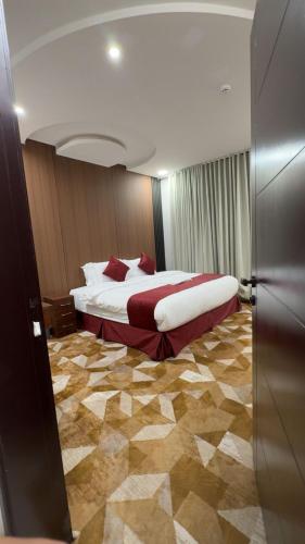 a hotel room with a large bed with red pillows at الجوهرة بارك للشقق المخدومة 7 in Riyadh