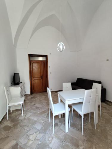 a dining room with a white table and white chairs at La NICCHIA in Monteroni di Lecce