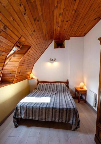 a bedroom with a large bed with a wooden ceiling at Gîte de Malavals in Castelnau-de-Mandailles
