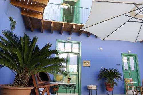 a room with a blue wall with tables and plants at To Konatzi tis Marikas tzai tou Yianni in Kato Drys