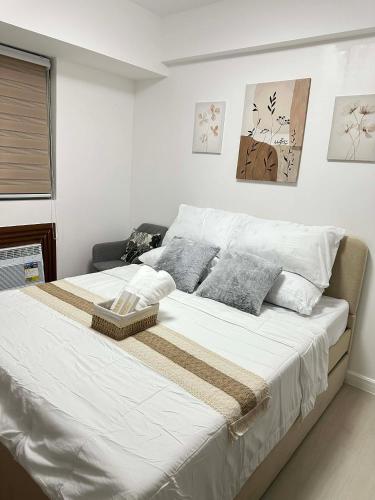 a bedroom with a large bed with white sheets and pillows at The Waltham Place in Lagundi
