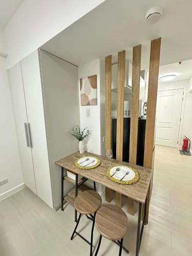 a dining room table with two stools and a table with plates and glasses at The Waltham Place in Lagundi