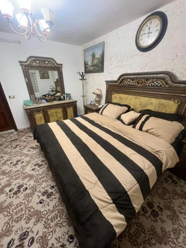 a bedroom with a large bed and a clock on the wall at اربد الحي الشرقي in Irbid