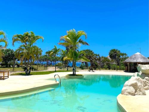 a swimming pool at a resort with palm trees at Basecamp Changani in Dar es Salaam