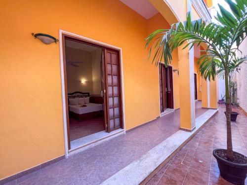 Ein Haus mit orangefarbenen Wänden und einer Palme im Innenhof in der Unterkunft Maya Campeche Hotel in Campeche