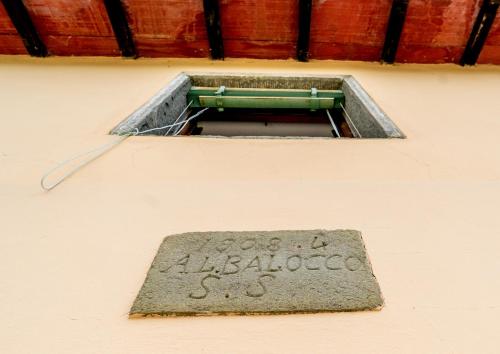 a plaque on the side of a building with a window at Balocco Countryside Home 1908 - Barga in Sommocolonia