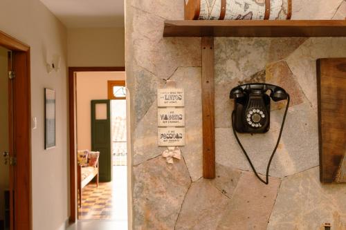 a phone hanging on a stone wall in a room at Casa Antunes in Diamantina