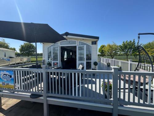 a small house with an umbrella on a playground at Millfields Holiday Park - The Balmoral - Coastal Caravan Breaks in Ingoldmells