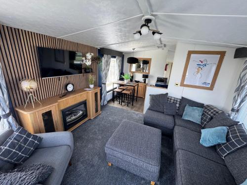 a living room with a couch and a tv at Millfields Holiday Park - The Balmoral - Coastal Caravan Breaks in Ingoldmells