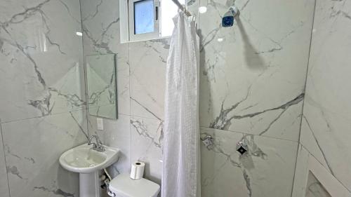 a bathroom with a sink and a toilet and a shower at HOTEL REAL UCUM in Ocum