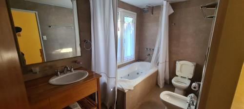 a bathroom with a sink and a tub and a toilet at Laderas Verdes in Esquel