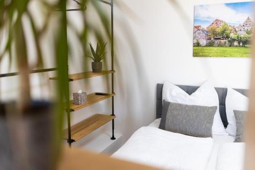 a bedroom with a white bed and a plant at Appartement im Weiherhaus in Forchheim