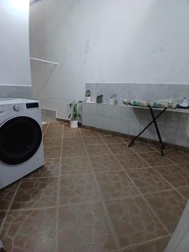 a bathroom with a washing machine and a tiled floor at HEYSEN Haus in Tarapoto