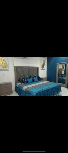 a bedroom with a bed with blue sheets and a mirror at Gemela1 in Puerto Peñasco