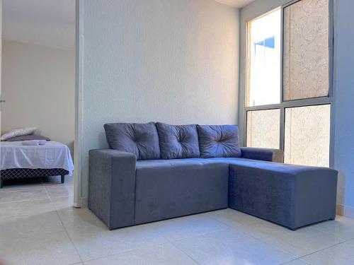 a blue couch in a room with a window at Aconchego e praticidade ao lado da BR-040 in Luziânia