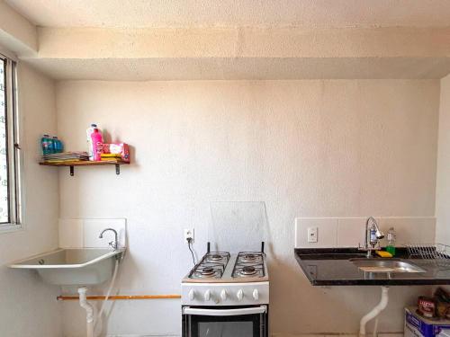a kitchen with a stove and a sink at Aconchego e praticidade ao lado da BR-040 in Luziânia