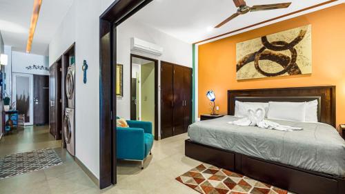 a bedroom with a bed and a blue chair at Penthouse Oceanview 1 block Malecon bars shops ZR in Puerto Vallarta