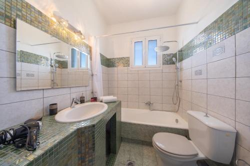 a bathroom with a sink and a toilet and a tub at Gerasimos Dream House - 7 Minutes from the Airport in Lakíthra