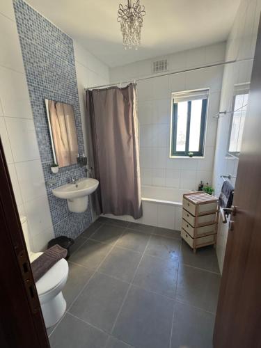 a bathroom with a toilet and a sink and a shower at Tommy's Retreat Xewkija in Xewkija