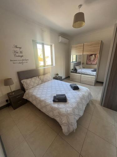 a bedroom with a bed with two bags on it at Tommy's Retreat Xewkija in Xewkija