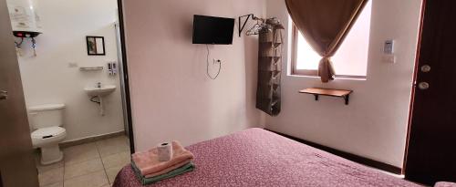 a bathroom with a bed and a toilet and a window at Casa Rosanna in Campeche