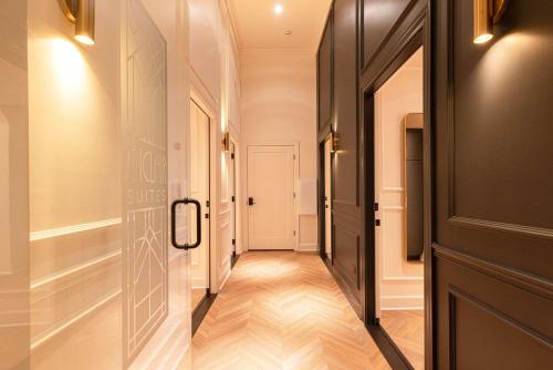 a hallway with a black door and wooden floors at Sinclair Suites - Boutique Hotel West Dundee in West Dundee