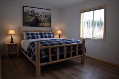 a bedroom with a bed and a picture of a moose at The Cabins at Riptide Resort in Seward