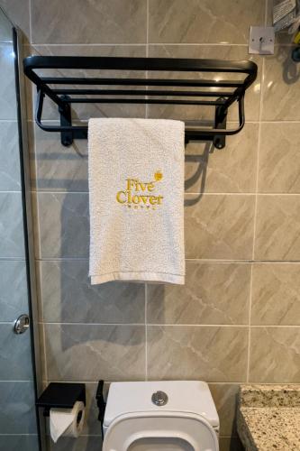 a towel hanging on a towel rack above a toilet at Five Clover Monastery Road in Lagos