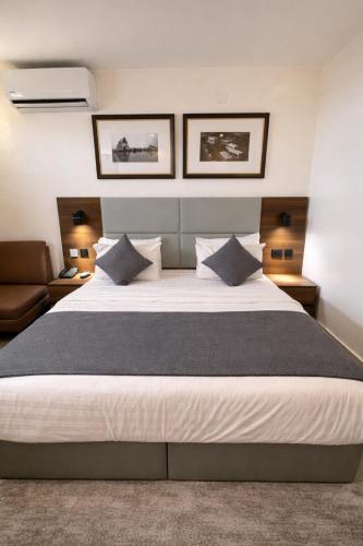a bedroom with a large bed and a couch at Five Clover Monastery Road in Lagos