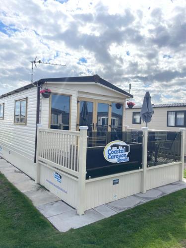 a mobile home with a porch and a deck at Golden Palm Resort - St David - Coastal Caravan Breaks in Chapel Saint Leonards