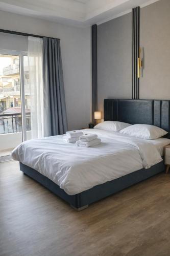 a large bed in a bedroom with a large window at Mézzo Lago in Missolonghi