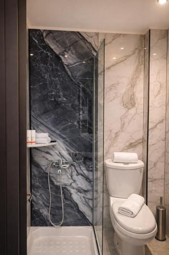 a bathroom with a toilet and a glass shower at Mézzo Lago in Missolonghi