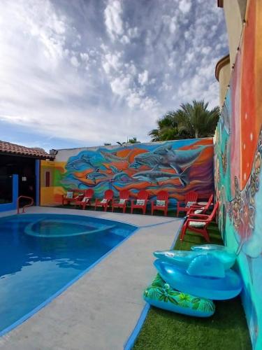 a pool with a mural on the side of a building at Hotel Casa Victoria in Puerto Peñasco