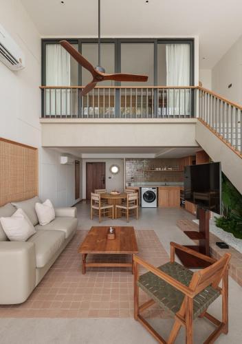 a living room with a couch and a table at Pano Samui Beachfront Villas in Nathon Bay
