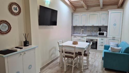 a kitchen with a white table and a table and chairs at Su Chélu in Villasimius