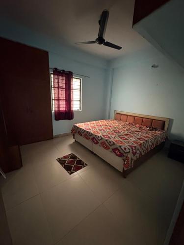 a bedroom with a bed and a window at Apna Ghar in Bhopal