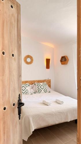 a bedroom with a bed with a wooden door at La Calma de Vilo in Periana