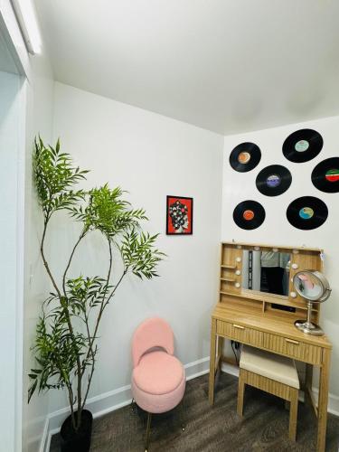 a living room with a desk and a pink chair and records at Retro Retreat in Wilson