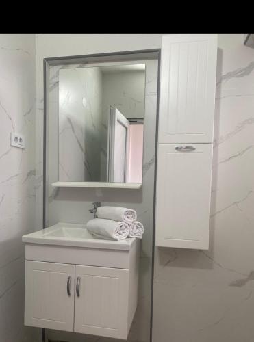 a white bathroom with a sink and a mirror at New Apartments Blue in Ulcinj