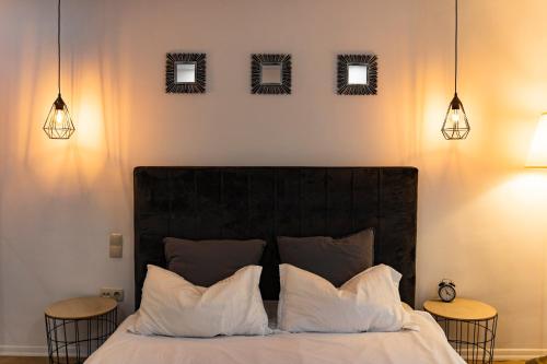 a bedroom with a bed with three mirrors on the wall at Seyra Home Studio - Modern Flat Pool Free Parking Self Check-in in Ştefăneştii de Sus
