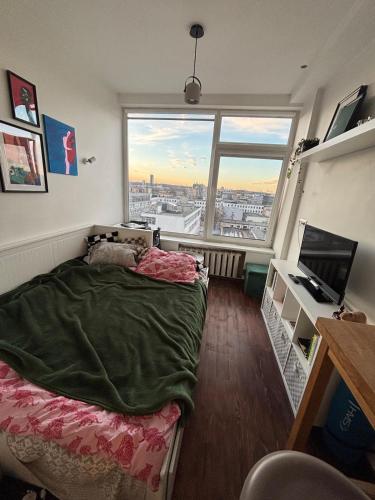 a bedroom with a bed and a large window at Cosy Newtown apartment in Vilnius