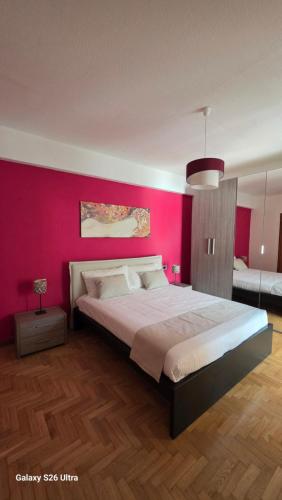a bedroom with a large bed with a pink wall at Casa Luisa in Recco